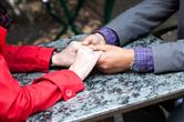 couple holding hands across table closeup